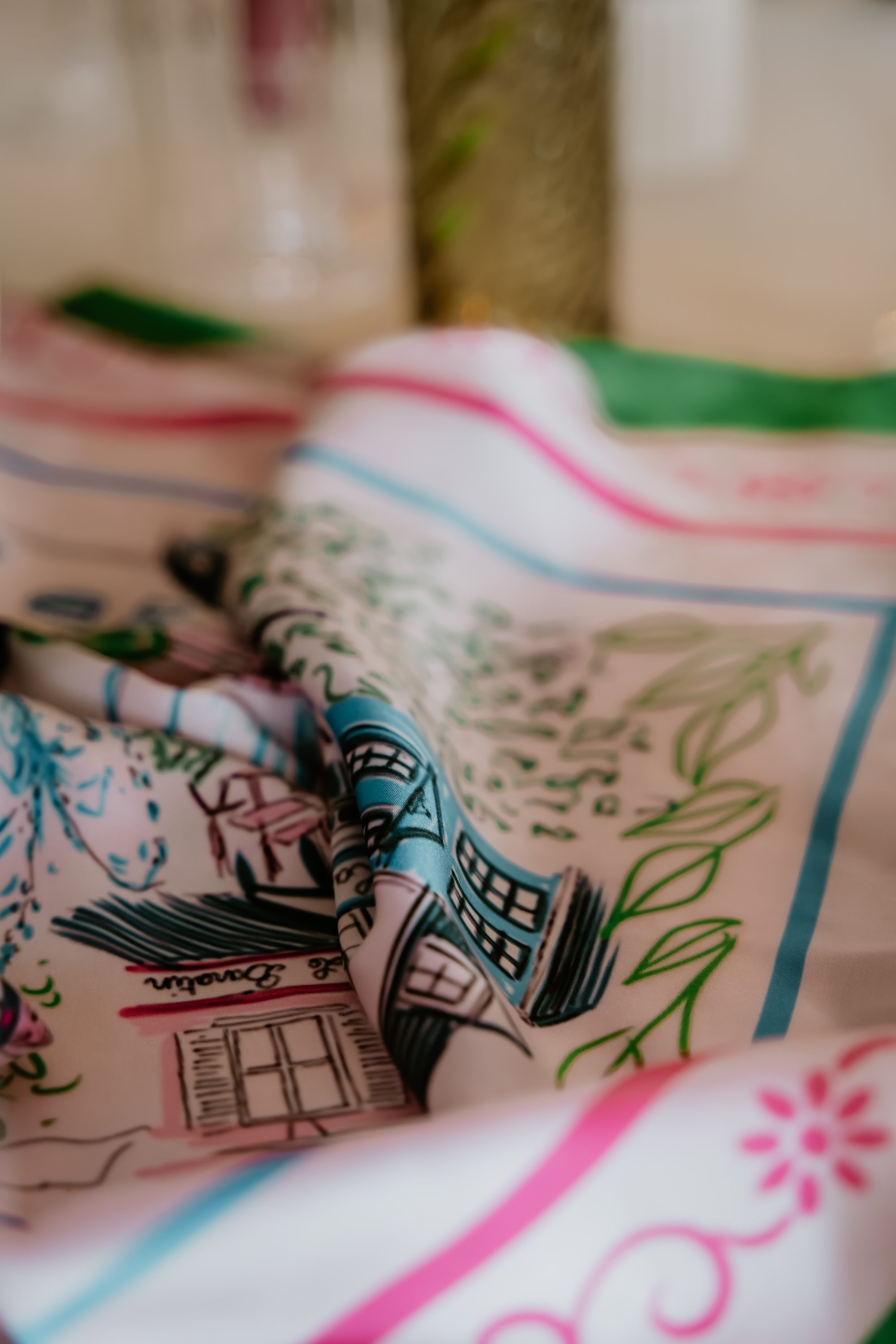 Foulard sur-mesure illustré posé sur un tissu, exemple de création